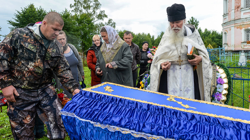 Padre Sergij, sacerdote della chiesa di San Flor e San Lavr a Florovskoe, nella regione di Yaroslavl, durante una celebrazione funebre al cimitero