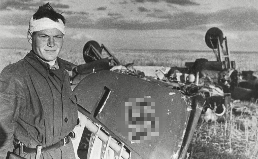 撃墜したナチスの飛行機の前でポーズを取る兵士 