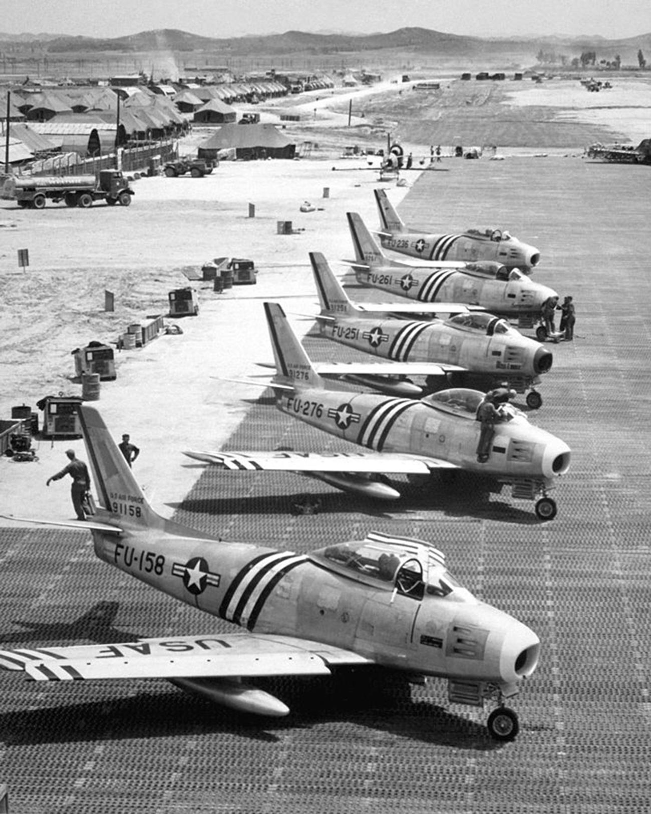 Vista de los aviones F-86 en la línea de vuelo preparándose para el combate.
