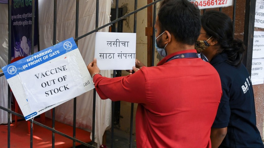 Profissional de saúde coloca cartaz, no qual lê-se “vacina fora de estoque”, em um centro de vacinação em Mumbai
