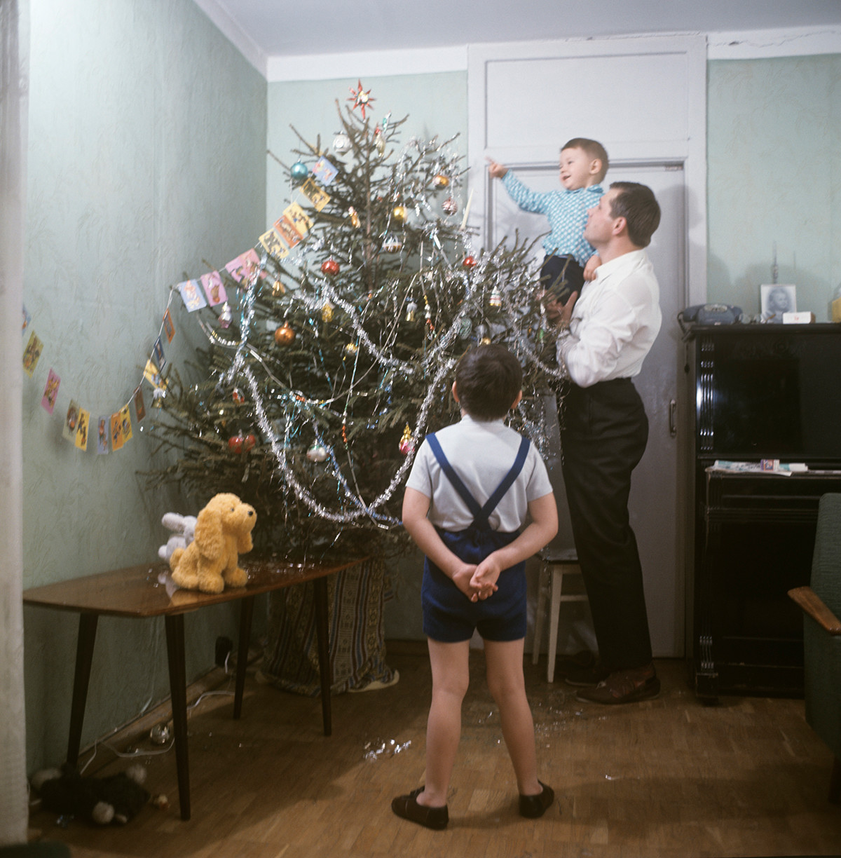 Ein Vater und seine Söhne schmücken den Baum an Silvester.