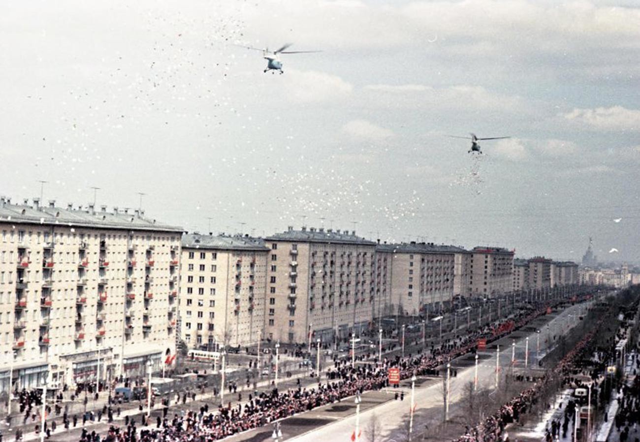 Des hélicoptères larguent des dépliants de bienvenue à l’intention du héros cosmonaute au-dessus de la ville