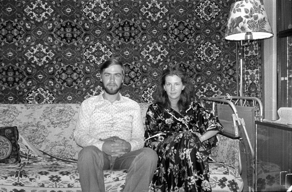 Foto di famiglia con il tradizionale tappeto appeso al muro 
