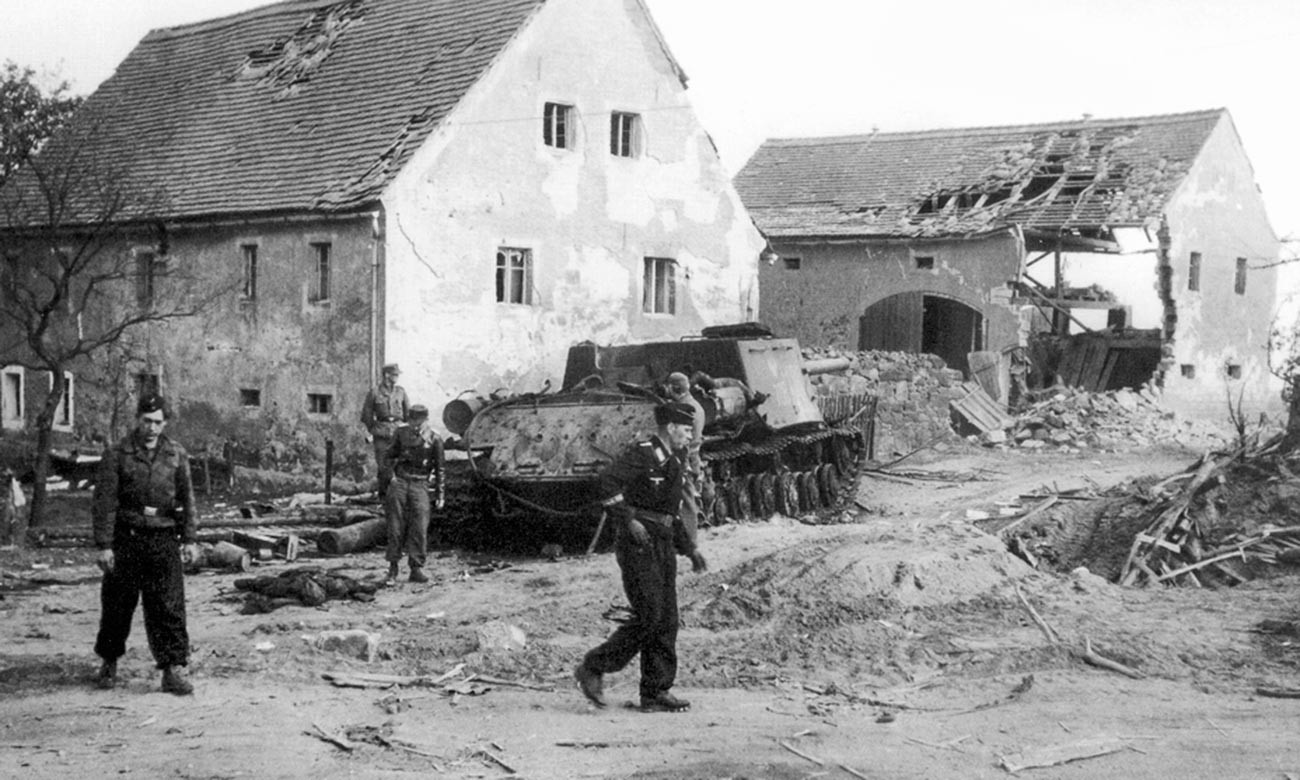 Немачки тенкисти разгледају уништен пољски самоходни тенк ИСУ-122 у насељу близу Бауцена.