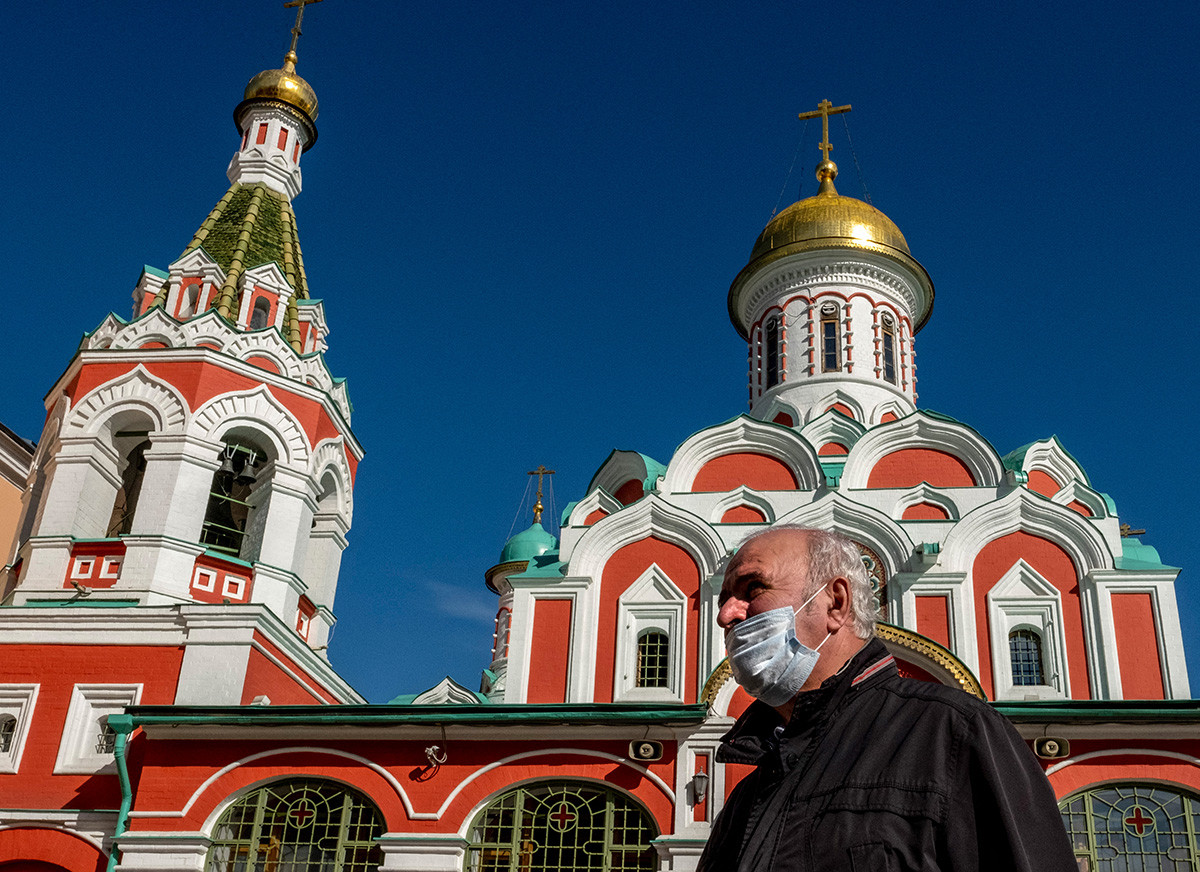Un signore con la mascherina contro il Covid passa davanti a una cattedrale ortodossa in Piazza Rossa a Mosca, 2 ottobre 2020