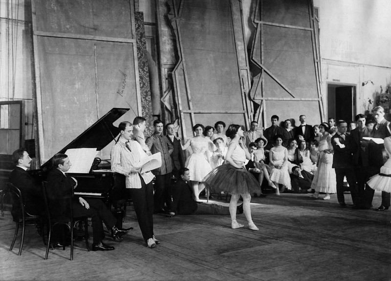 Ballets Russes during the rehearsal: at the piano on the right is composer Igor Stravinsky, and standing is Michael Fokine. In the center is ballerina Tamara Karsavina.