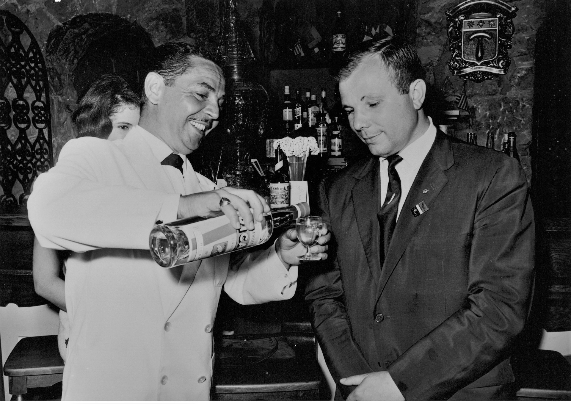 Gagarine prêt à déguster un pastis Ricard que le serveur est en train de lui
verser dans un verre. La photo est prise  dans le bar de l'hôtel Delos de l'île de Bendor