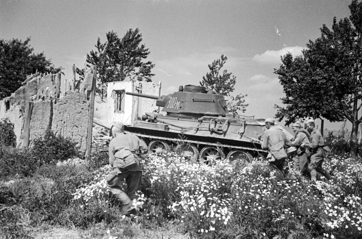 Un groupe de fantassins soviétiques couverts par un char passe à l'offensive en périphérie de Bucarest