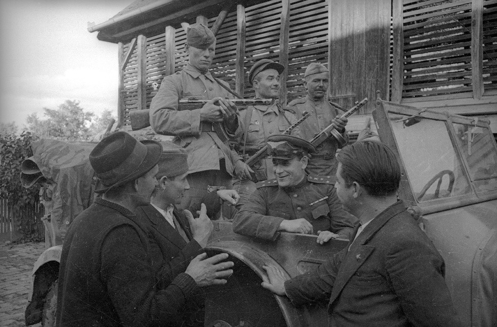 Des officiers soviétiques parlent aux habitants de la ville.
