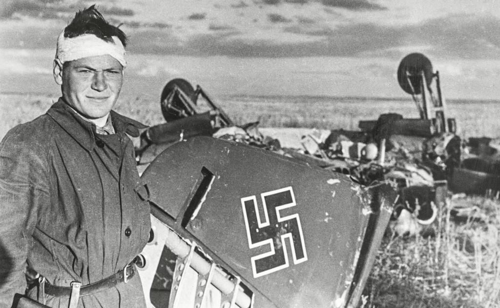 Un pilote posant avec un avion nazi qu'il a abattu
