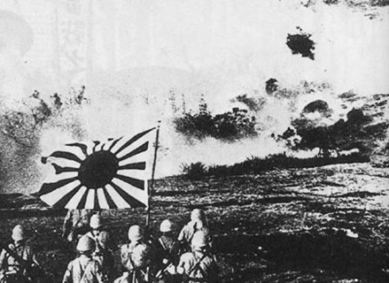 La fuerza de desembarco naval japonesa volando un fortín chino y marchando con la bandera naval durante la Operación Cantón