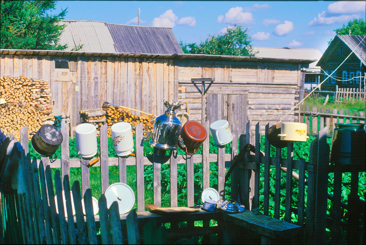 Varzuga. Patio lateral de una casa en la orilla izquierda. Ollas lavadas y samovar secándose en una valla. 21 de julio de 2001