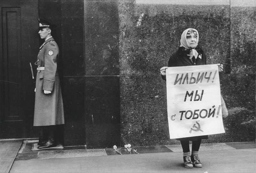 Eine Frau bei einer Kundgebung in der Nähe des Lenin-Mausoleums: Auf dem Plakat steht: „Iljich [Lenin], wir sind bei dir!“