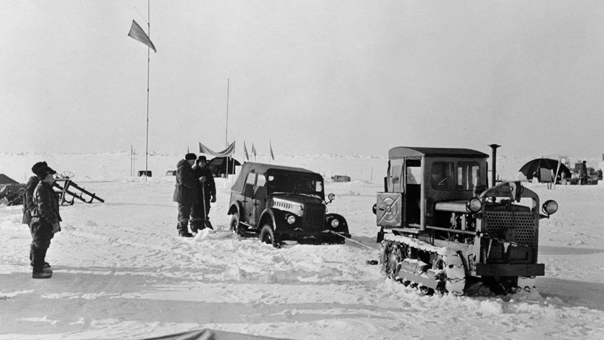 Tractor rescues disabled auto at one of the observation stations set up by Soviet Union scientists atop an ice floe in the Arctic region.