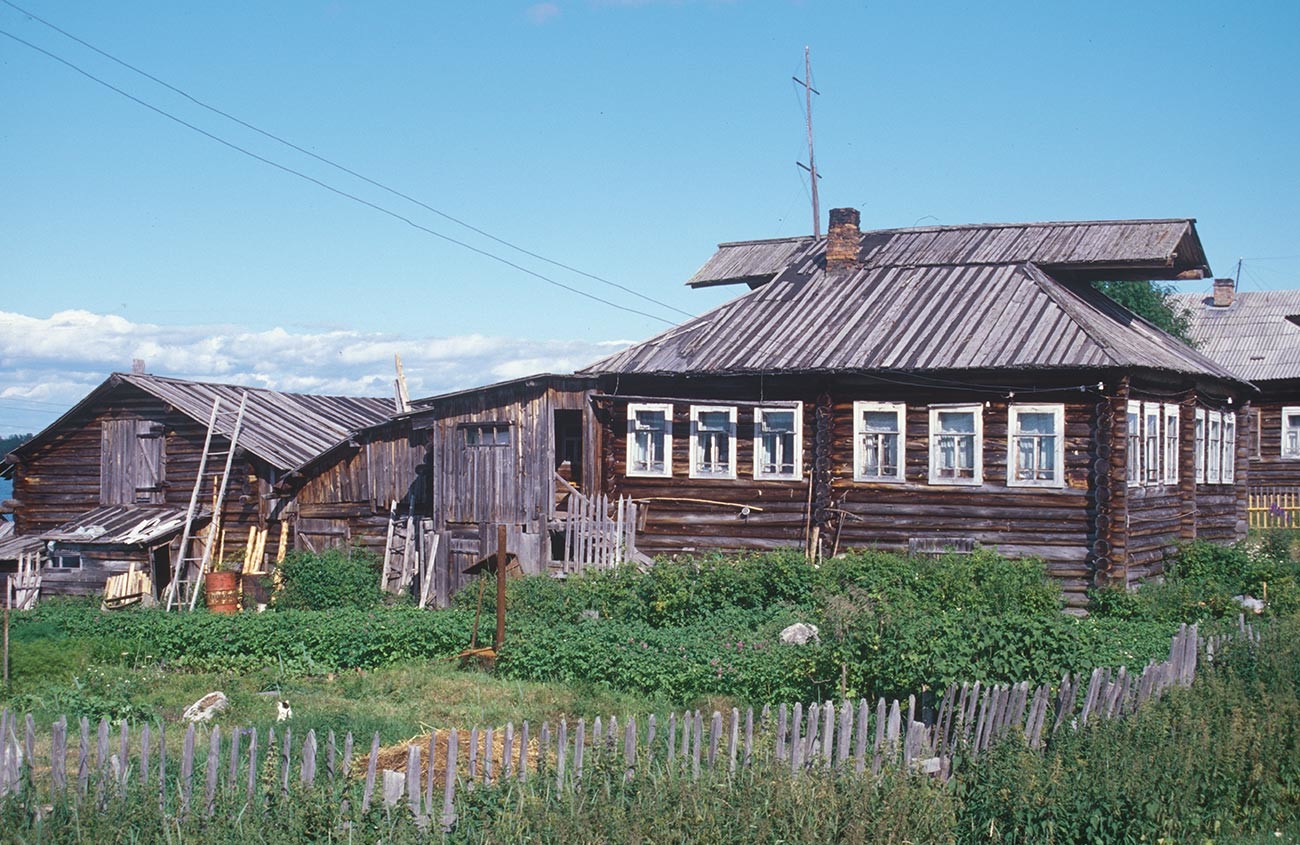 コヴダ村。丸太小屋と納屋。屋根に、覆い付きの切妻があることに注意。2001年7月24日。