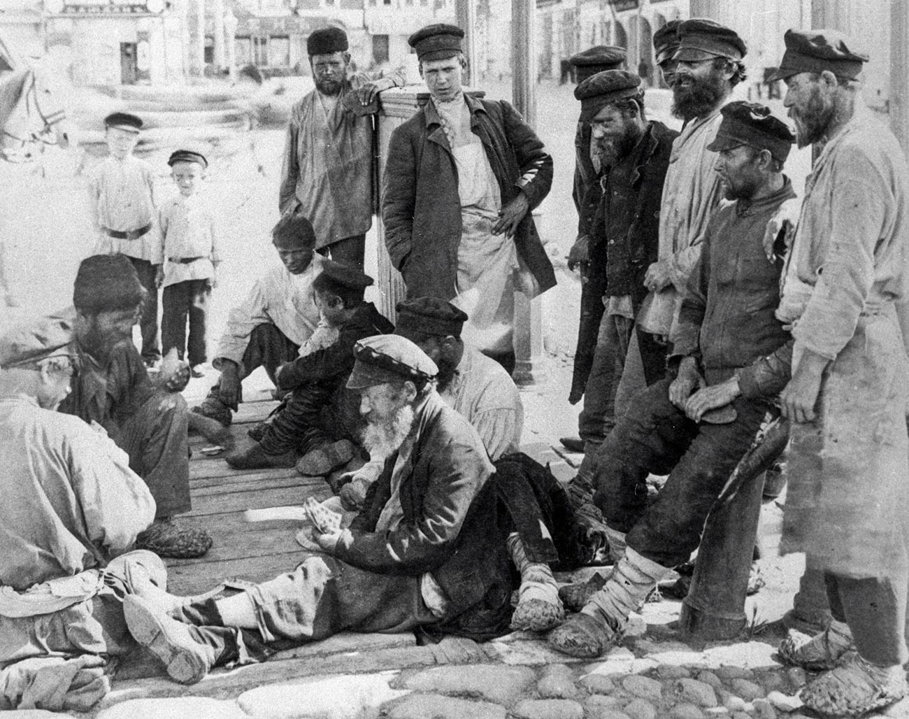 Des vagabonds jouant aux cartes dans la rue, fin du XIXe siècle