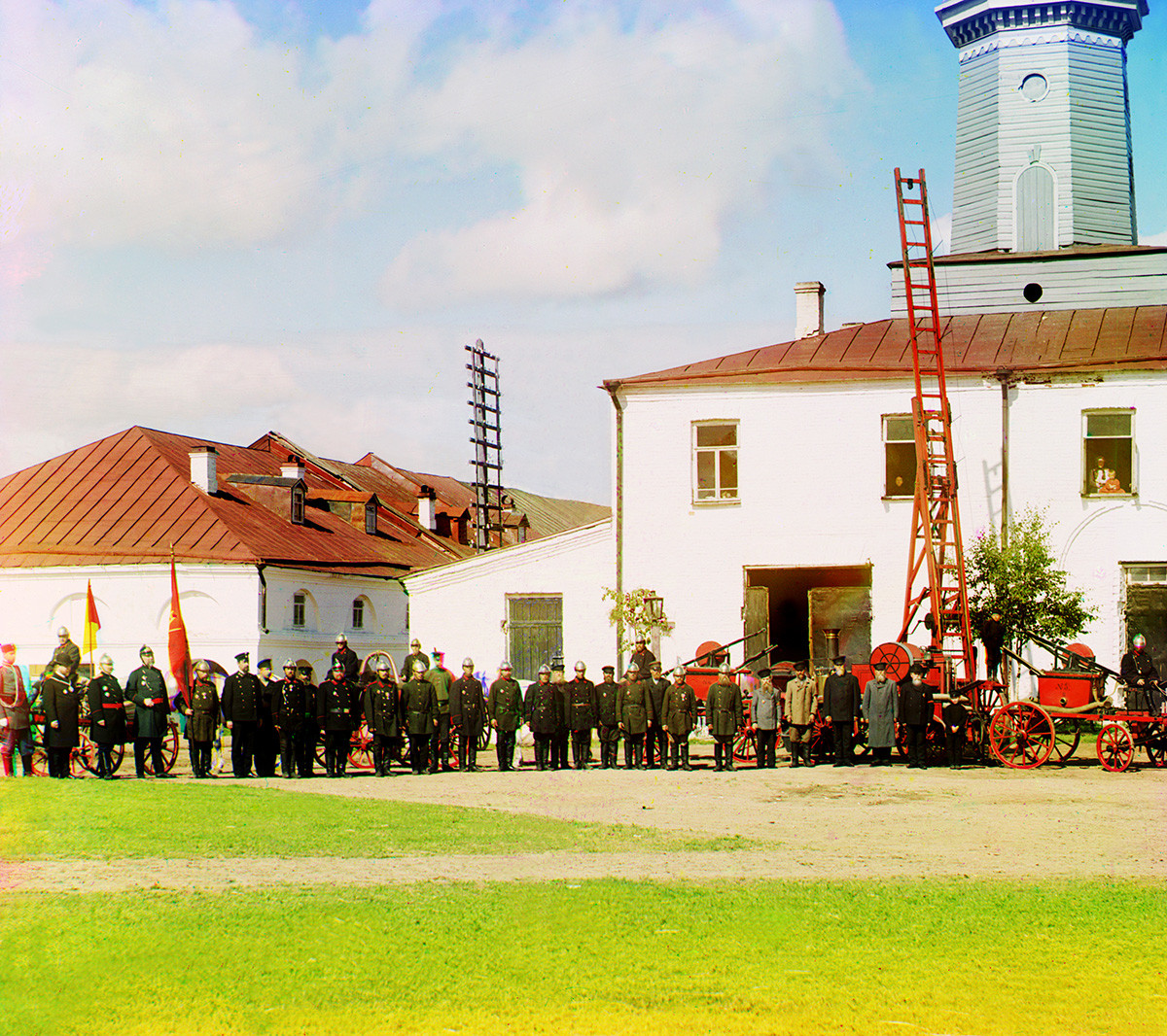 Fire station & watchtower with members of fire brigade & local administration. Left: partial view of Trading Rows. Summer 1909