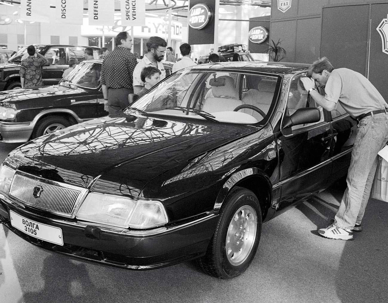 Посетители на Меѓународниот саем на автомобили 1995 година разгледуваат автомобил ГАЗ-3105 „Волга“.

