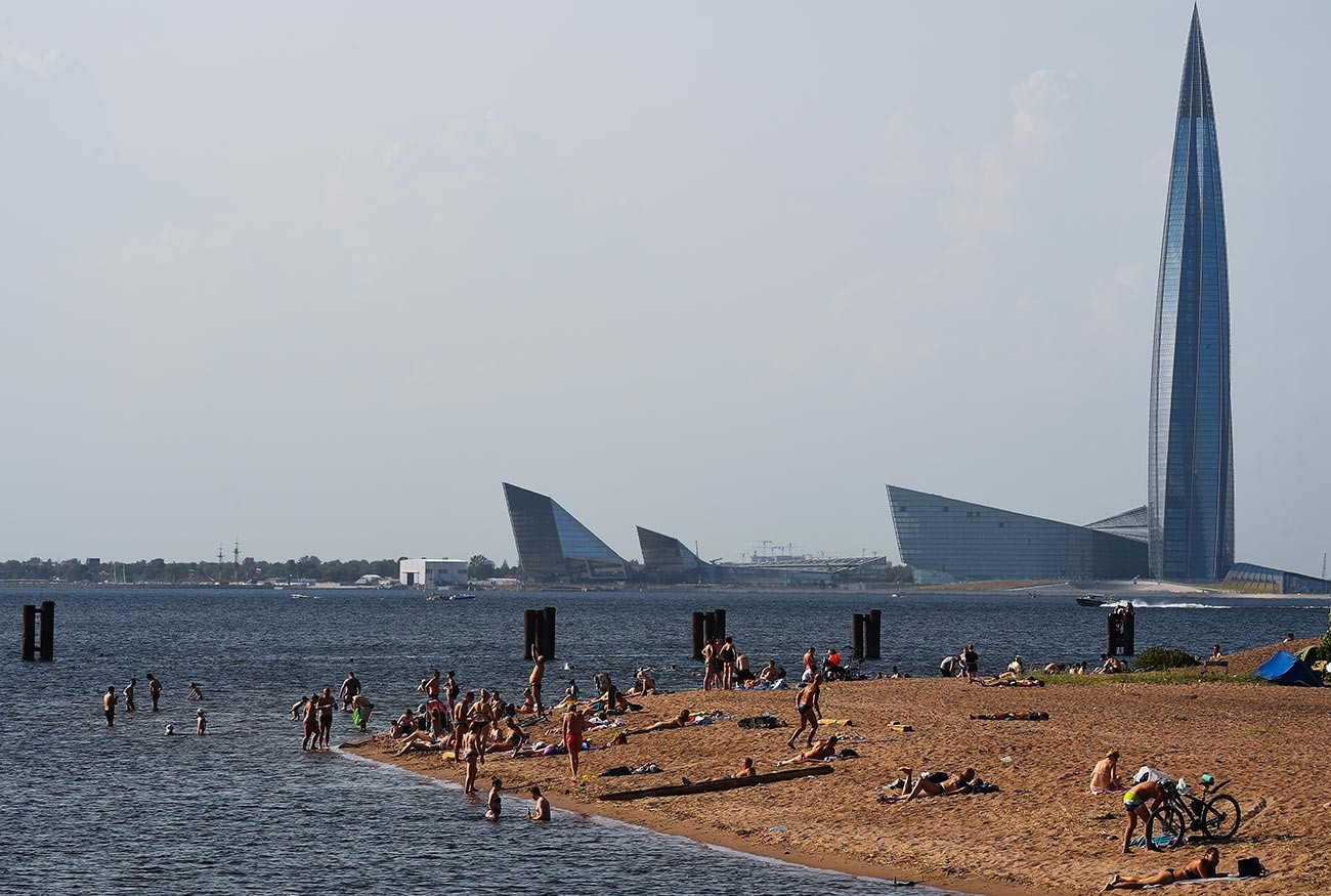 Люди на пляже на берегу Финского залива на Васильевском острове в Санкт-Петербурге. 