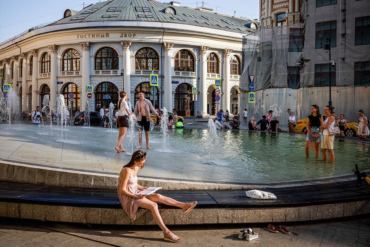 Orang-orang mendinginkan diri di air mancur selama hari musim panas di Kota Moskow, 22 Juni 2021.