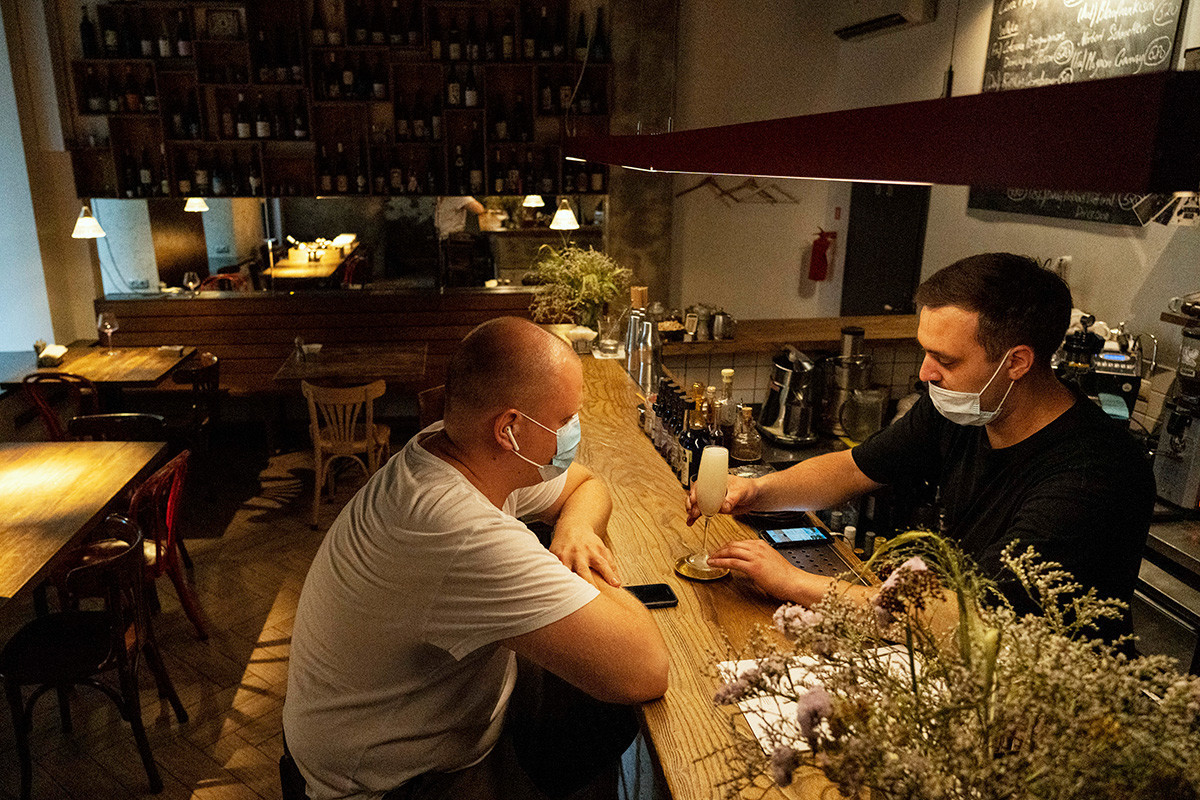 Atendente serve coquetel no bar Moments, geralmente lotado, porém quase vazio depois que restaurantes e cafés começaram a solicitar códigos QR de vacinação ou teste de coronavírus negativo em Moscou, na segunda-feira (28)
