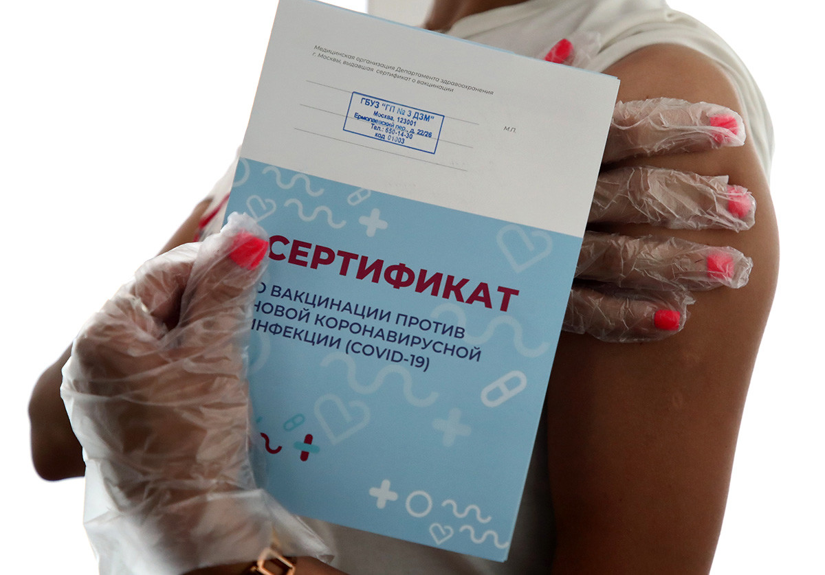 A woman receives a certificate after a COVID-19 vaccine injection at a Healthy Moscow pavilion in the Muzeon Art Park. The facility offers injections of the Gam-COVID-Vac (Sputnik V) and Vector's EpiVacCorona vaccines.