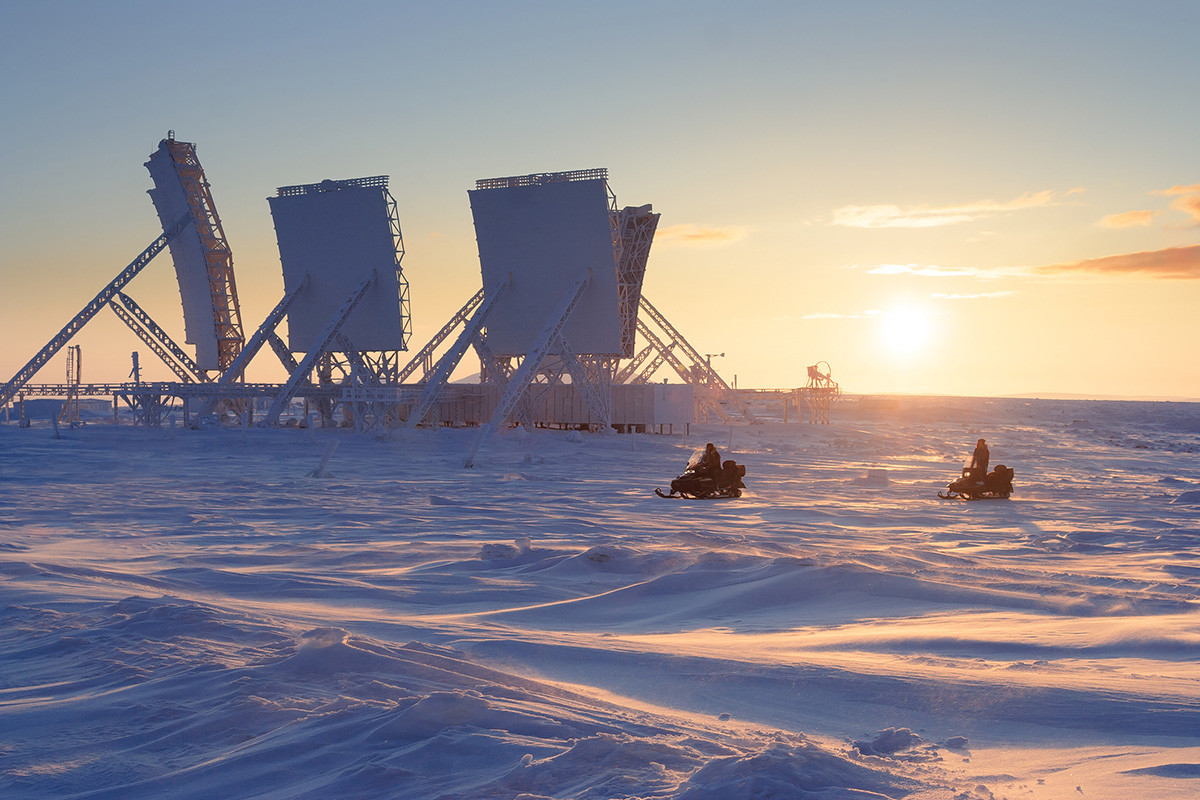 Lanskap arktik selama musim dingin dengan kompleks antena besar stasiun “troposcatter” yang ditinggalkan.