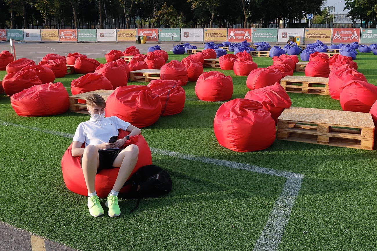 Seorang suporter bersantai sendirian di zona penggemar di Stadion Luzhniki, Moskow.