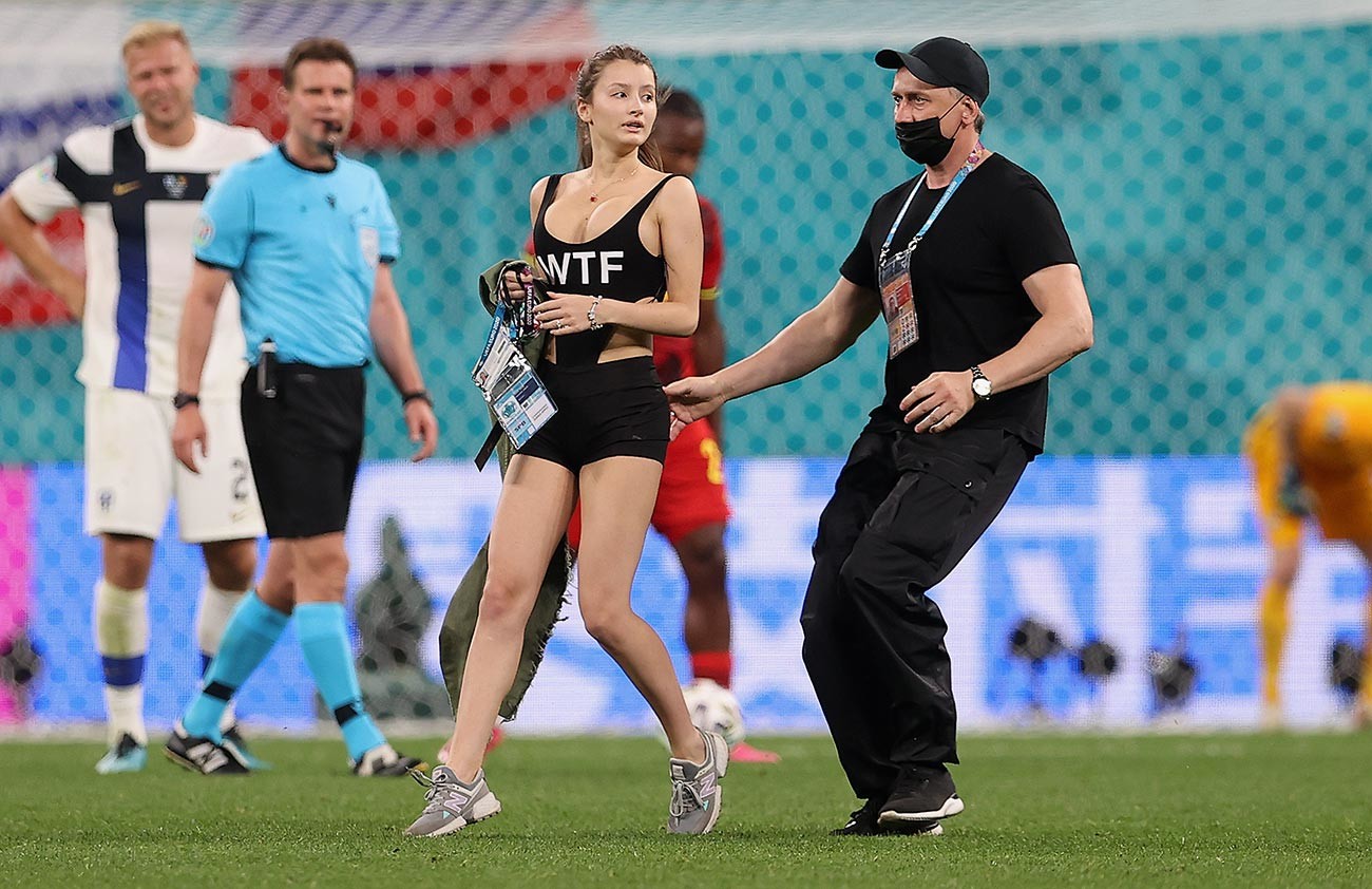 Seorang perempuan dikeluarkan dari lapangan oleh staf lapangan di tengah pertandingan Grup B Kejuaraan Euro 2020 antara Finlandia dan Belgia di Stadion Sankt Peterburg, 21 Juni 2021.