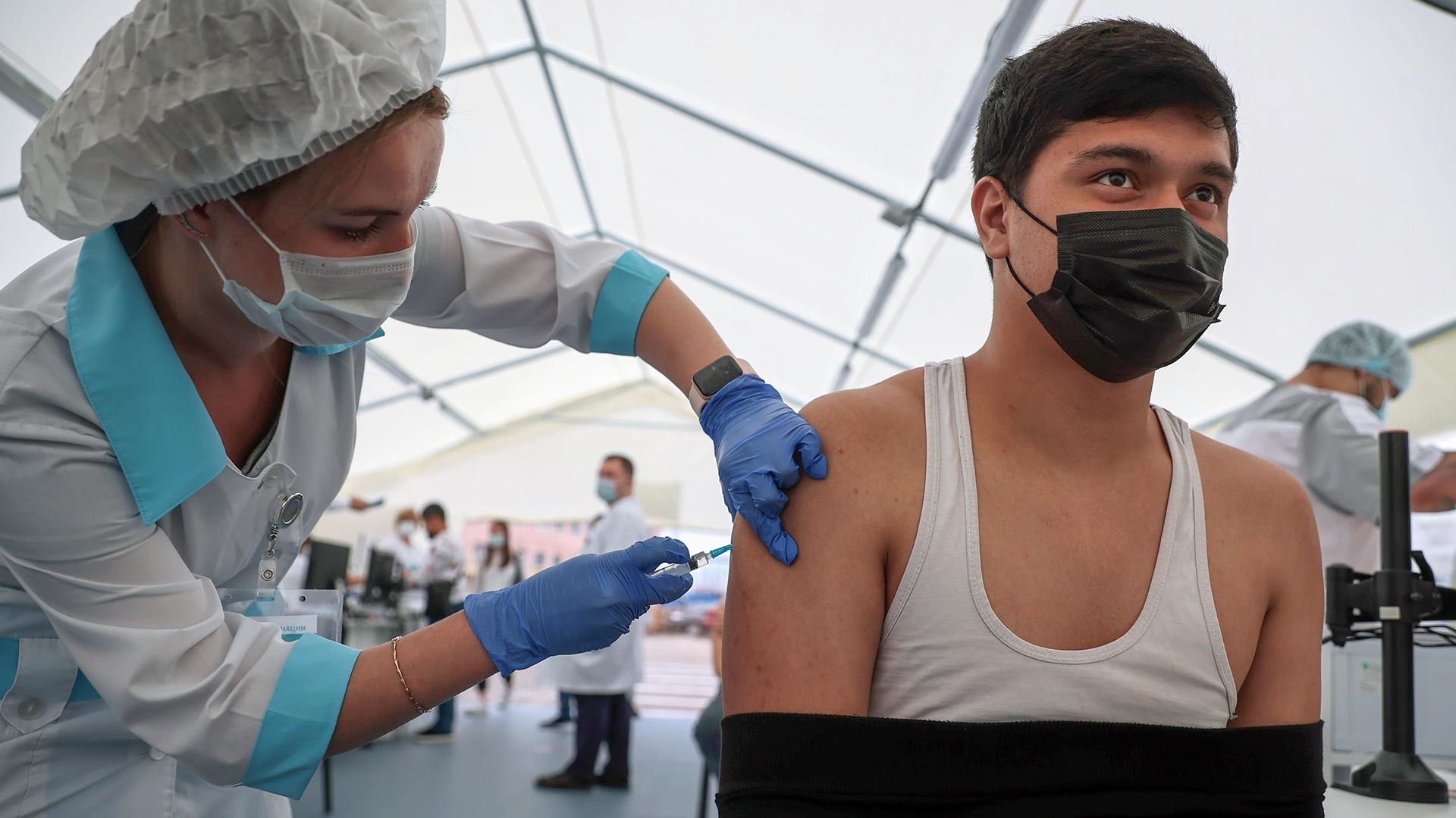 Seorang pekerja medis menyuntikkan vaksin  COVID-19 kepada warga asing di wilayah pusat perbelanjaan Sadovod, Moskow, Rusia.