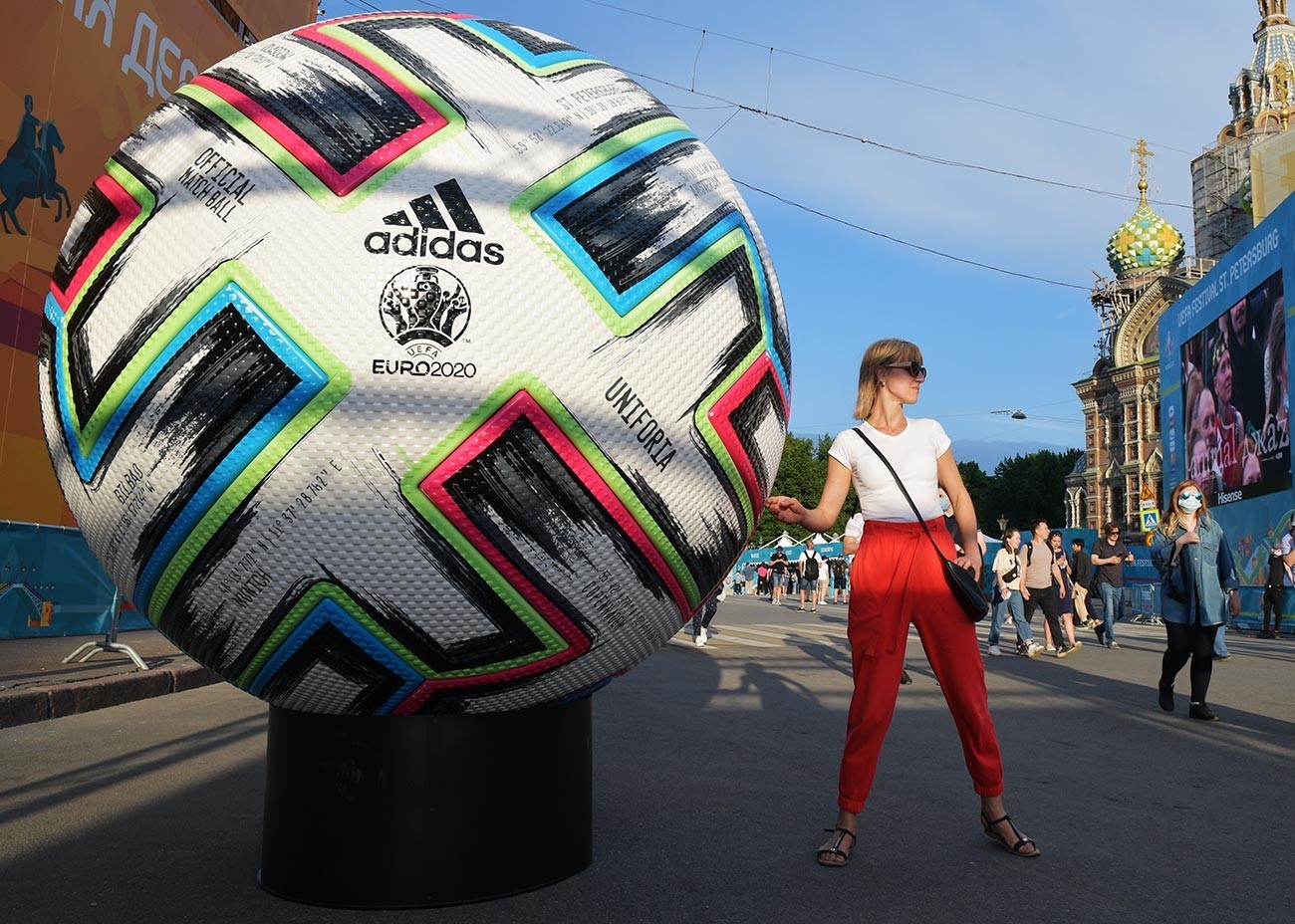 Dekle se fotografira ob kopiji uradne žoge evropskega nogometnega prvenstva 2020 v navijaški coni na trgu Konjušennaja v Sankt Peterburgu.
