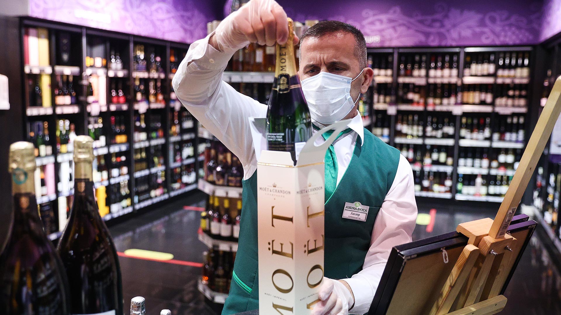 Служител на стелажа с пенливи вина Moet Hennessy в супермаркет 