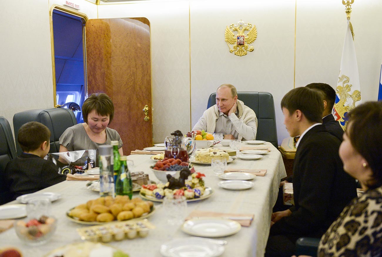Путин во время встречи на борту президентского самолета с семьей младшего сержанта Баира Банзаракцаева.