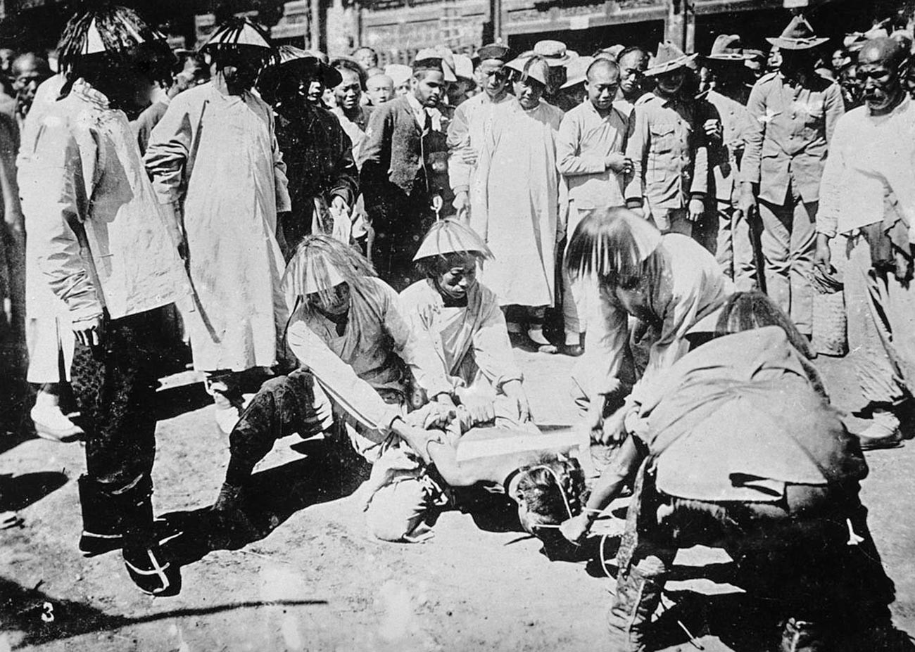 Un bóxer siendo decapitado frente a una multitud de chinos.
