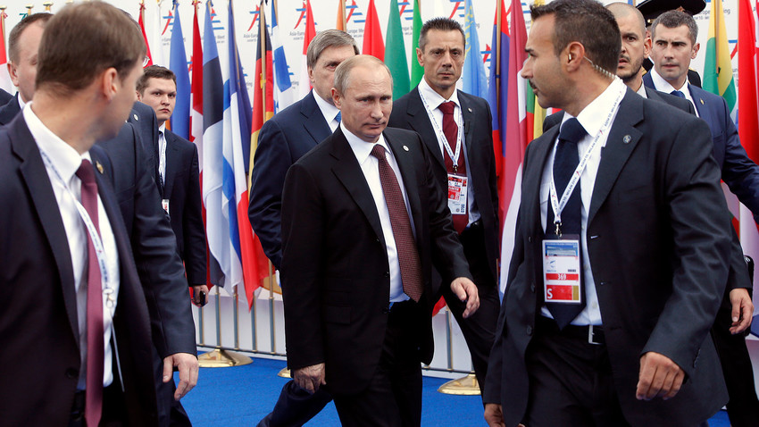 Vladimir Putin, obkrožen s telesnimi stražarji med zapuščanjem vrha Evropa-Azija (ASEM) v Milanu 17. oktobra 2014. 