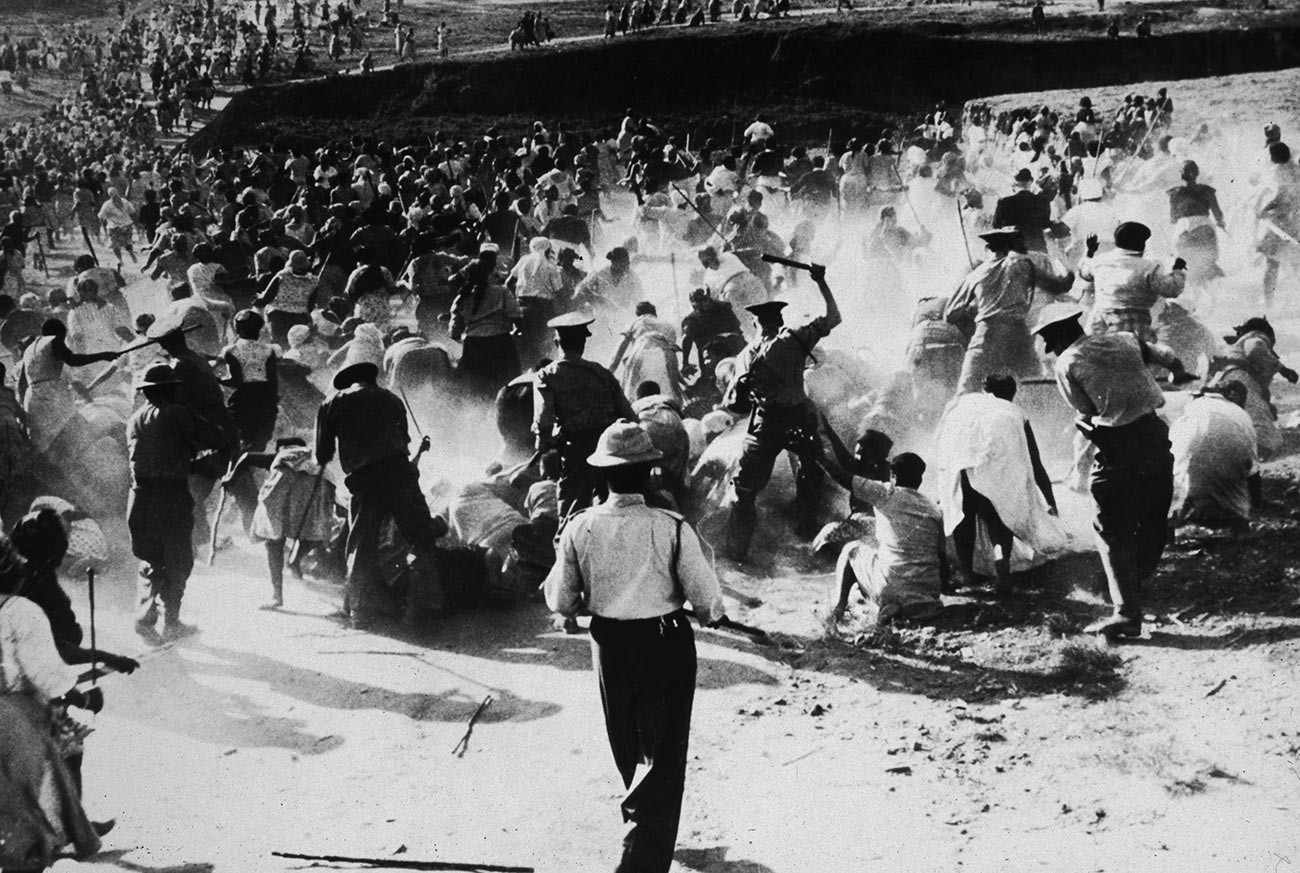 South African police beating Black women with clubs after they raided and set a beer hall on fire in protest against apartheid, Durban, South Africa.