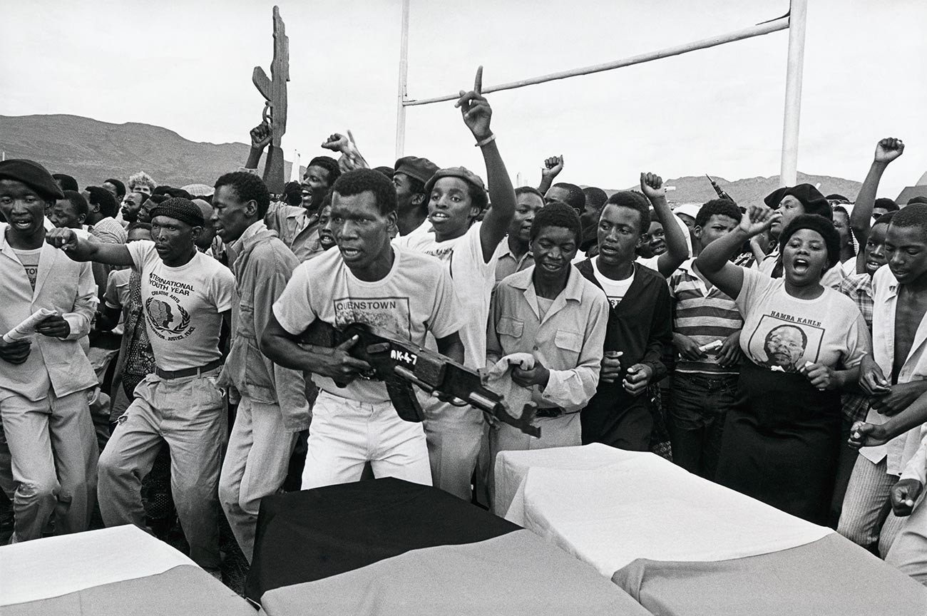 Ožalošćeni mašu replikama drvenih pištolja i pjevaju u znak podrške zabranjenom Afričkom nacionalnom kongresu na sprovodu militanata Afričkog nacionalnog kongresa ubijenih u Queenstownu u Južnoj Africi.