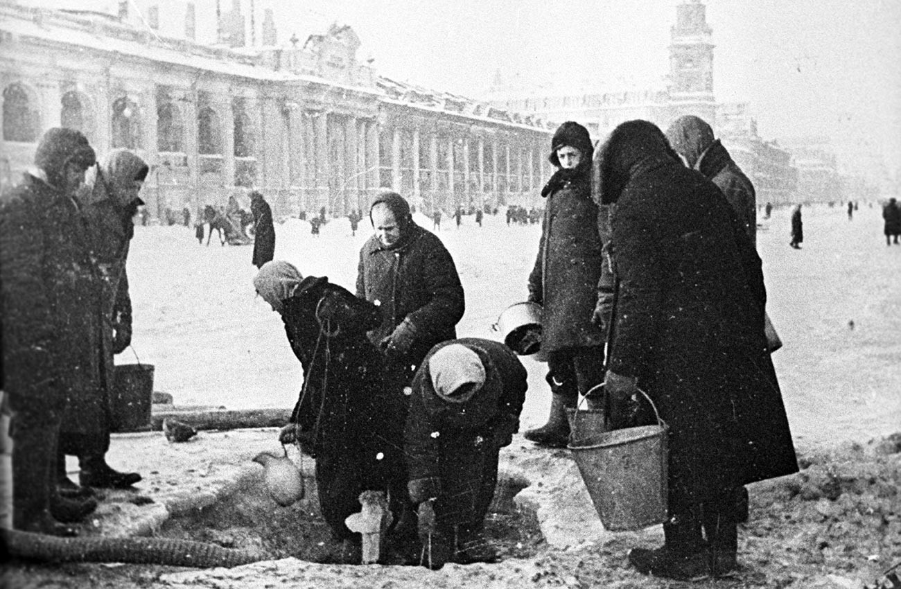 Des habitants de Leningrad durant le siège collectent de l'eau sur la perspective Nevski, dans des trous de la chaussée causés par des bombardements