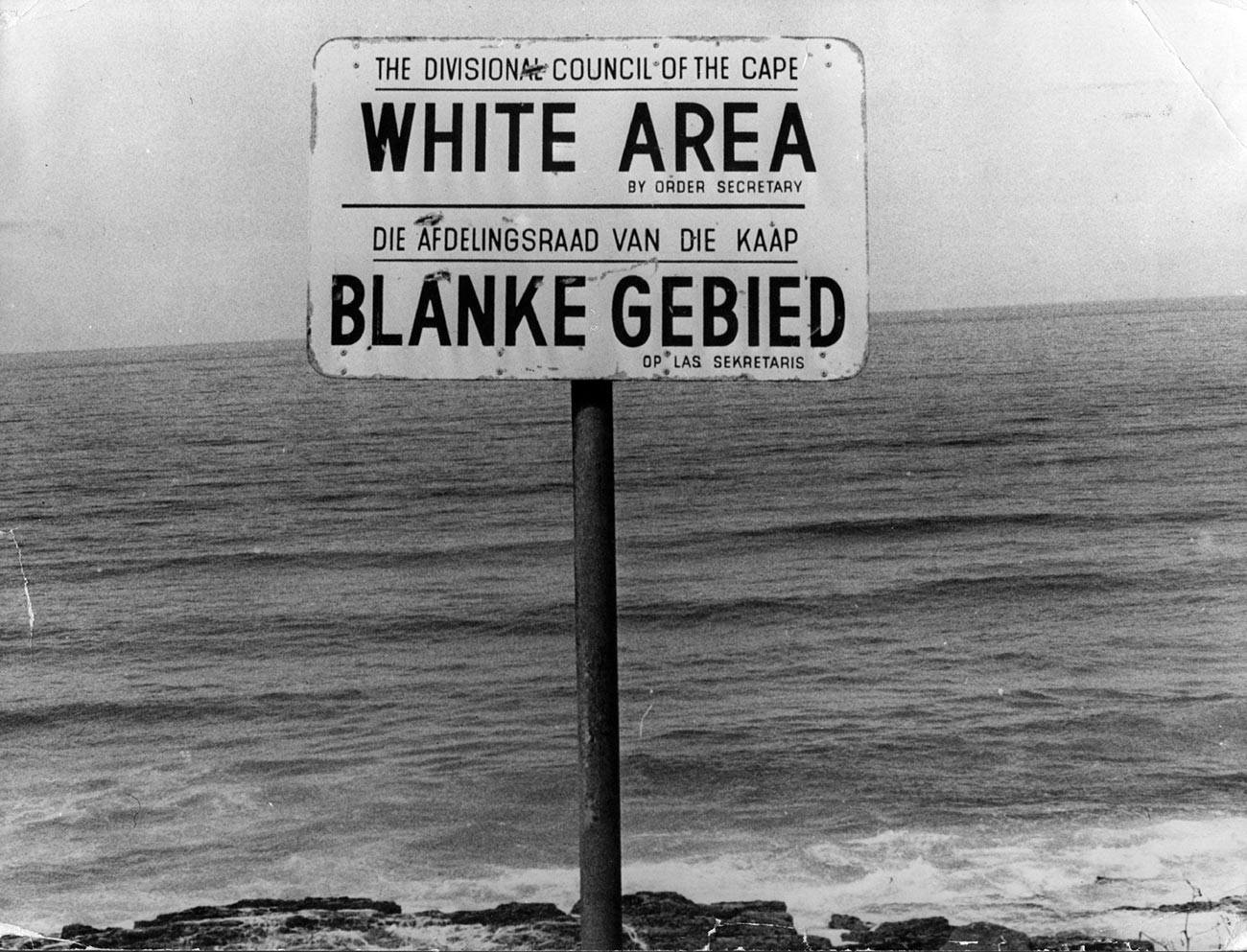 Placa de Apartheid em uma praia perto da Cidade do Cabo, demarcando área apenas para brancos
