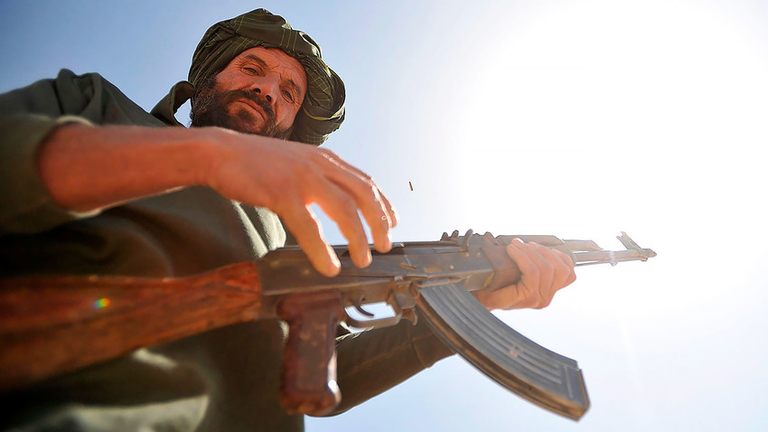 Афганистански служител от местната полиция се подготвя да стреля с  АК-47 по цели по време на тренировъчен оръжеен курс в област Навабахар, провинция Забул, Афганистан