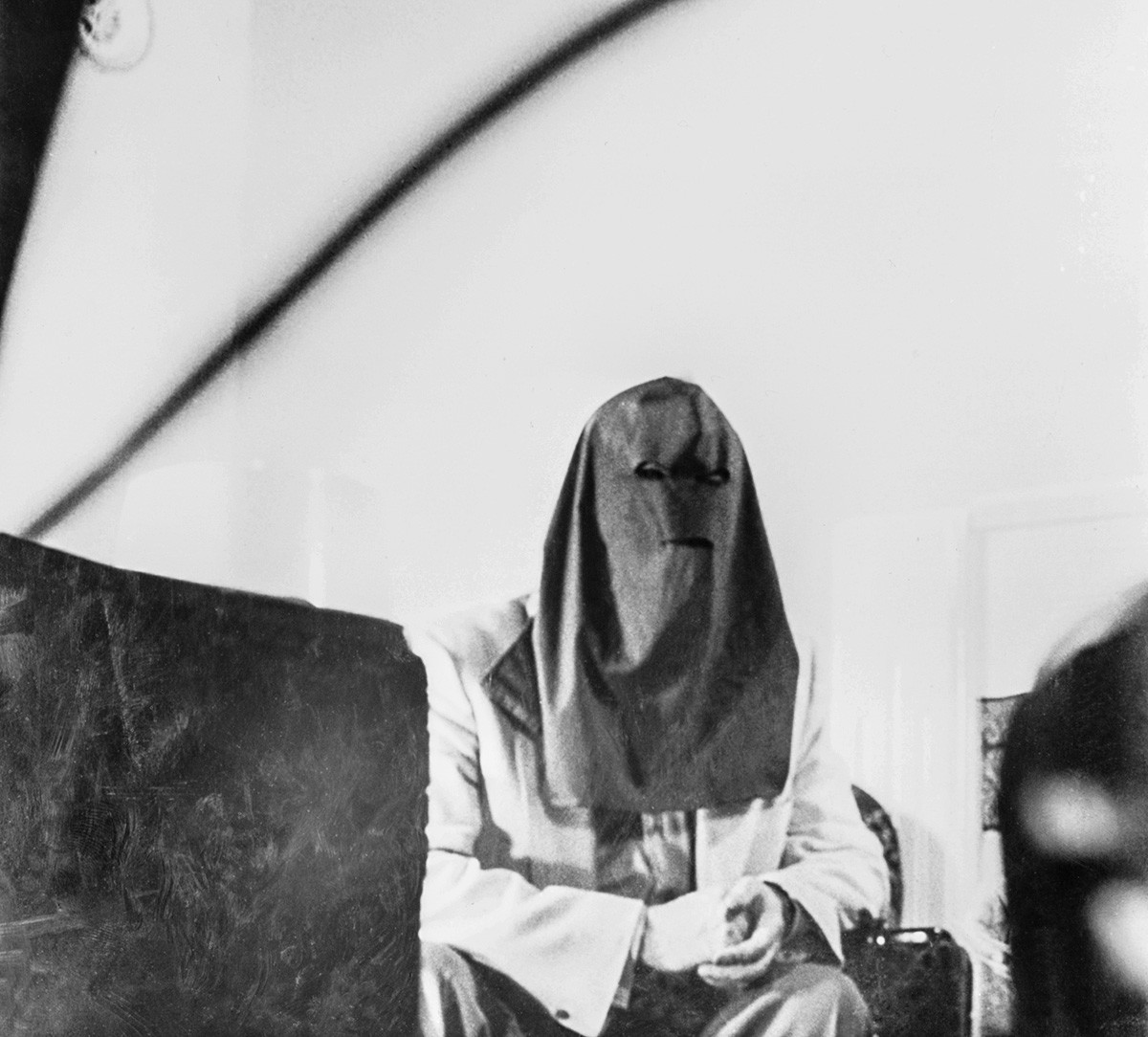 Igor Gouzenko, former decoding clerk in the Russian Embassy in Toronto who exposed a Red spy ring operation in Canada, is shown in the first photo ever permitted of him since he became a marked man...He is wearing a specifically designed hood to foil future identification.