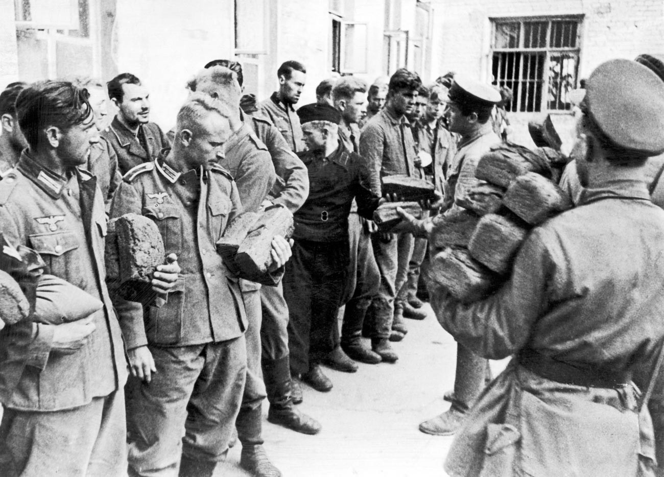 Los prisioneros de guerra alemanes capturados por las fuerzas rusas son alimentados con pan por los soldados rusos durante la Segunda Guerra Mundial. 9 de agosto de 1941.
