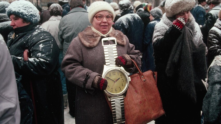 Soviet woman shows off a clock shaped like a wristwatch.