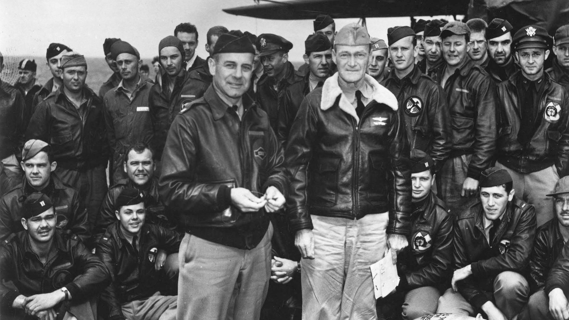 Дулитлов напад на Јапан, 18. априла 1942: потпуковник и вођа напада Џејмс К. Дулитл, Ратна морнарица САД (леви фронт) и капетан Марк А. Мичер, командант носача авиона USS Hornet (CV-8) и пилоти САД пред полетање.