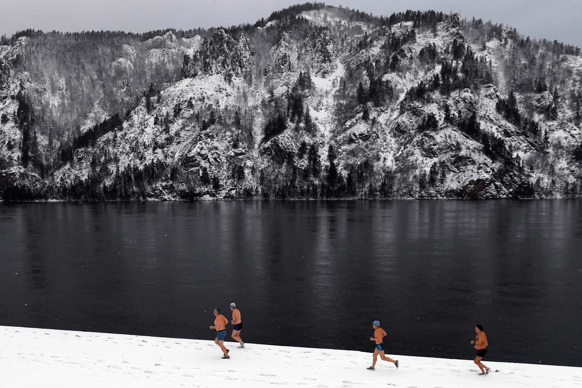 Člani zimskega plavalnega kluba tečejo čez reko Jenisej.

