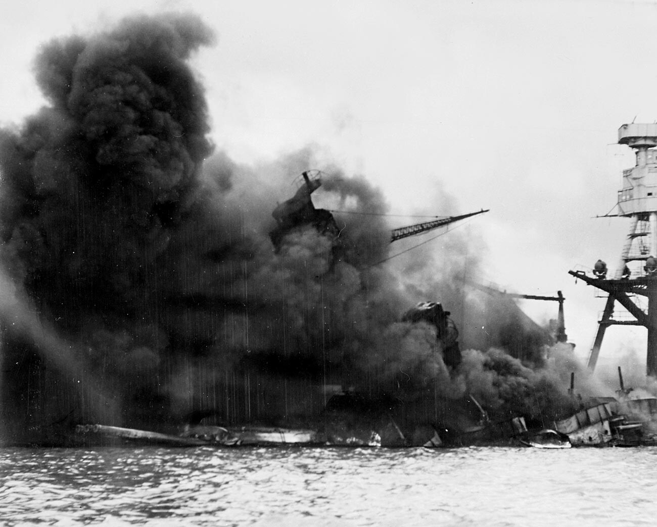 El USS Arizona hundiéndose en una nube de humo tras el ataque japonés a Pearl Harbor durante la Segunda Guerra Mundial.
