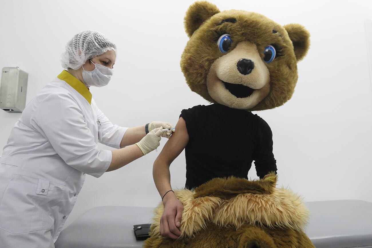 Medicinska sestra i animator trgovačkog centra u kostimu medvjeda za vrijeme cijepljenja prvom komponentom cjepiva 