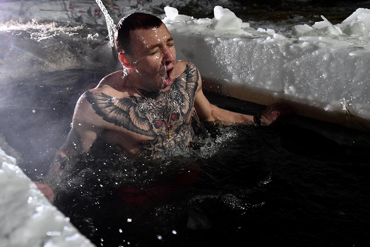 Un uomo si immerge nelle acque ghiacciate benedette per le celebrazioni dell'Epifania ortodossa