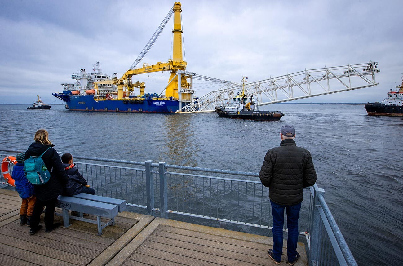 Alcuni passanti guardano dal molo la nave posatubi russa 
