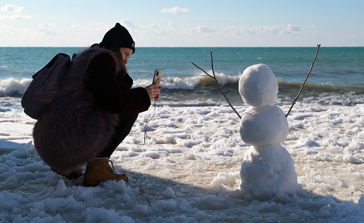 黒海沿岸の人気のリゾート地、ソチで作られたエキゾチックな南方の雪だるま。しかしこの雪だるまは助けを呼んでいるように見える。
